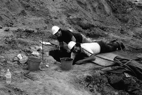 Leonard Forsman, right, a young man at the time (and, in later years to become the Chief of the Suquamish tribe) and a fellow worker examining a section of the 1992 dig site at West Point. Courtesy of King County. Collection held in trust at the Burke Museum, Seattle. 1992.