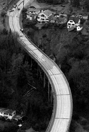 The January 1997 mudslide swept down the hill between two of the bridge’s support columns, knocking out cross braces and filling the navy home below the bridge with debris. Courtesy of The Seattle Times. 
